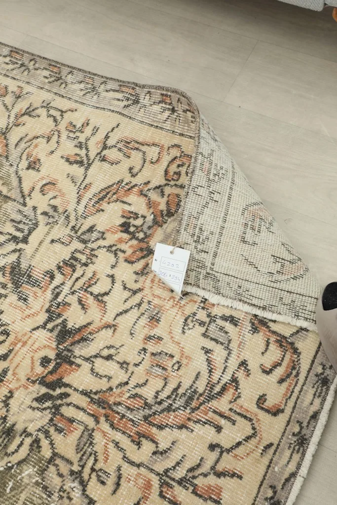 Detail of the rug's reverse side near a corner with a tag, showing the tight knotting.