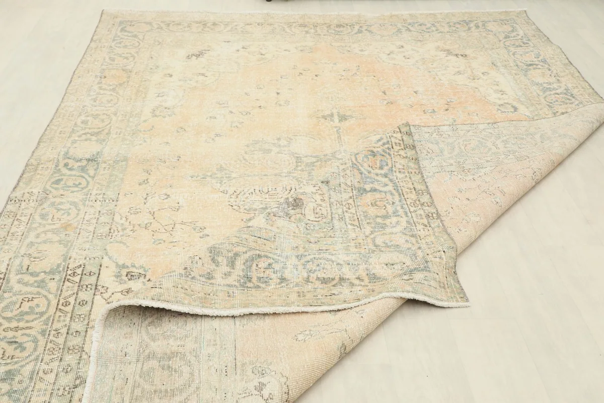 Rug partially folded, illustrating the flexibility and the overall condition of the vintage piece