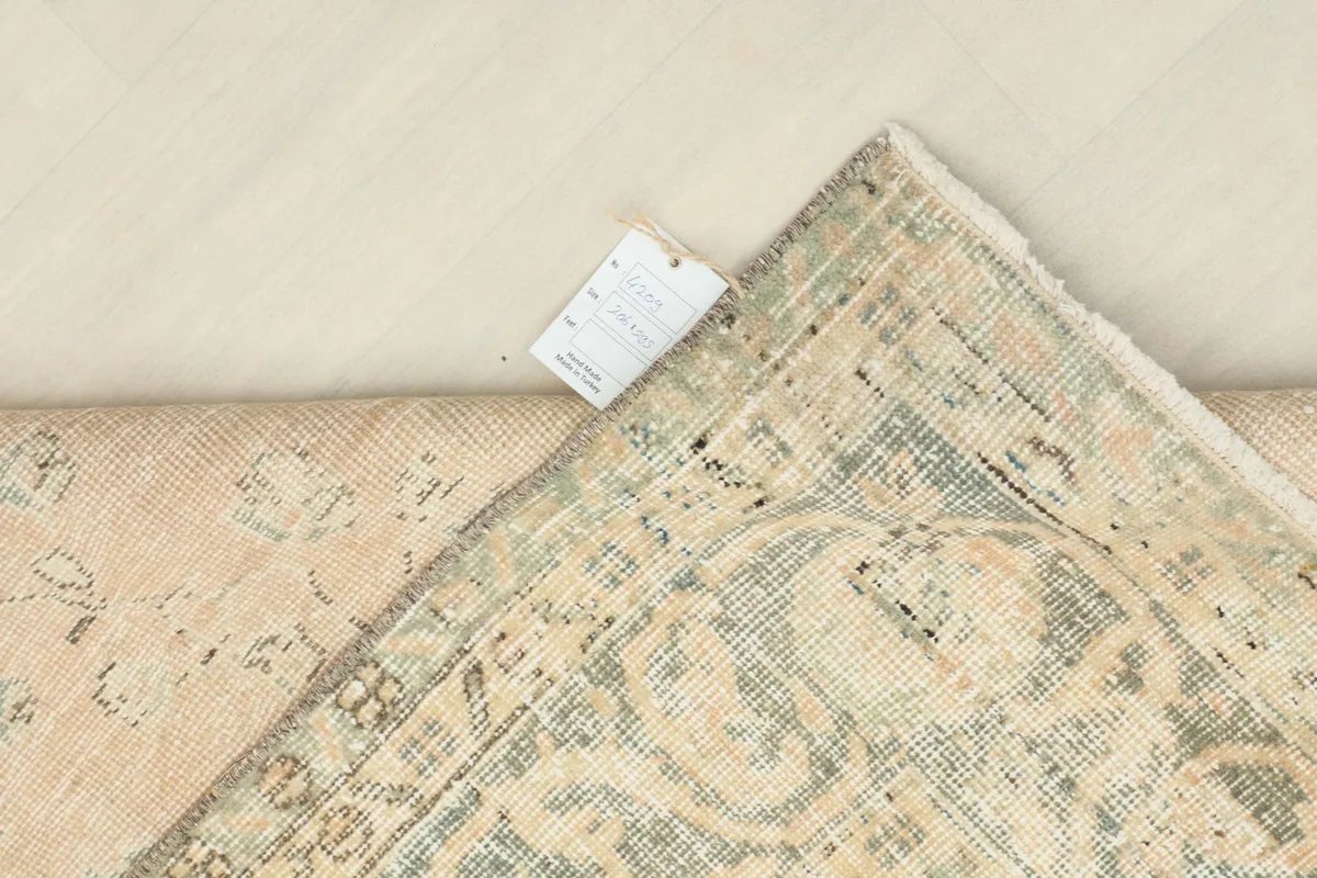 Corner of the rug with a tag, showing the reverse side's texture and craftsmanship