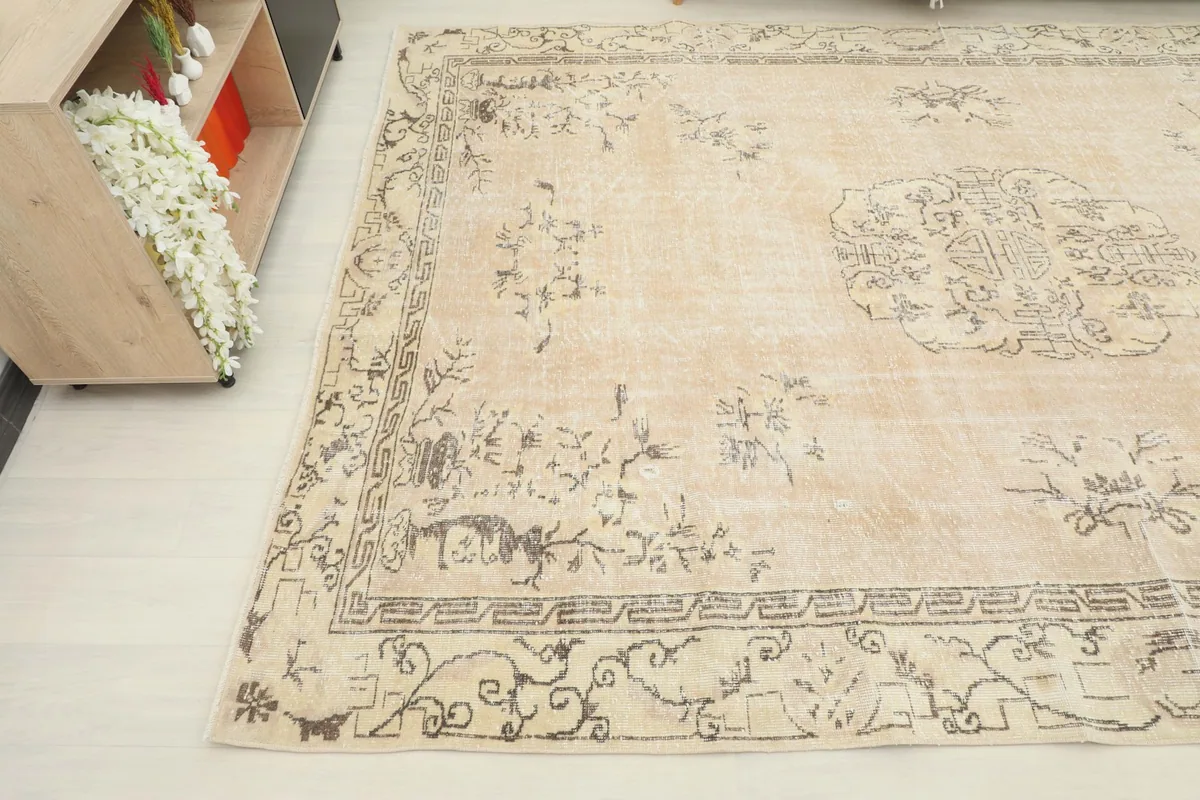 Perspective shot of the rug's corner, revealing faded floral motifs and the border design