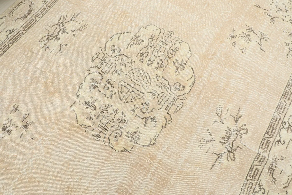 Detailed view of the central medallion motif and surrounding floral accents on the ivory field