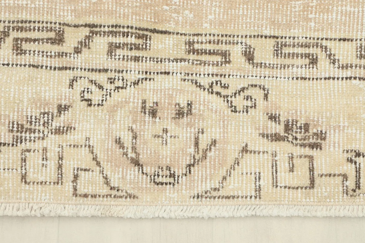 Detail of the rug's border, showcasing its geometric and subtle floral patterns