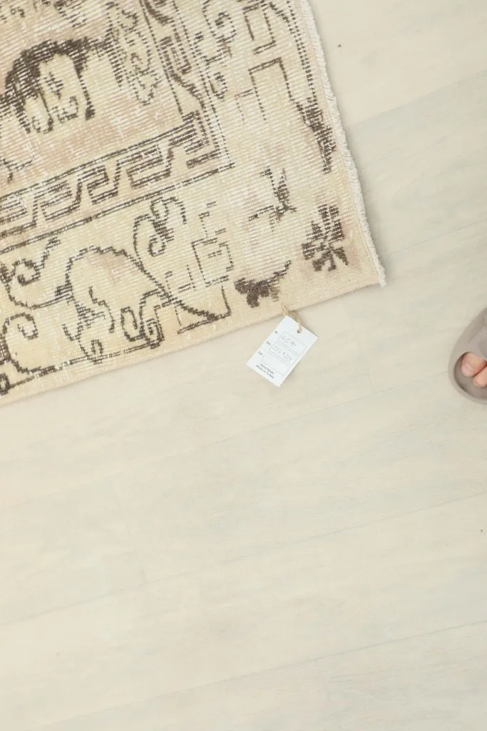 Corner of the rug with a small tag, showing the low pile and fringe detail