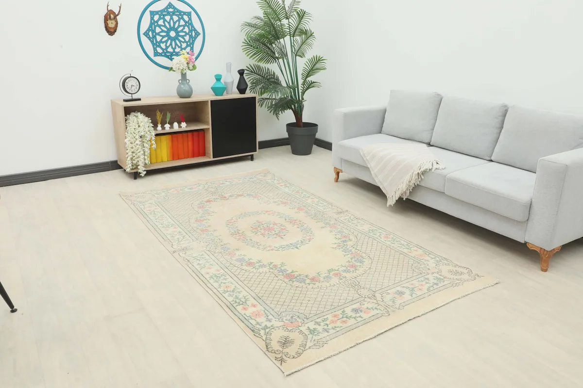 Ivory vintage area rug displayed in a modern living room setting with a light gray sofa.