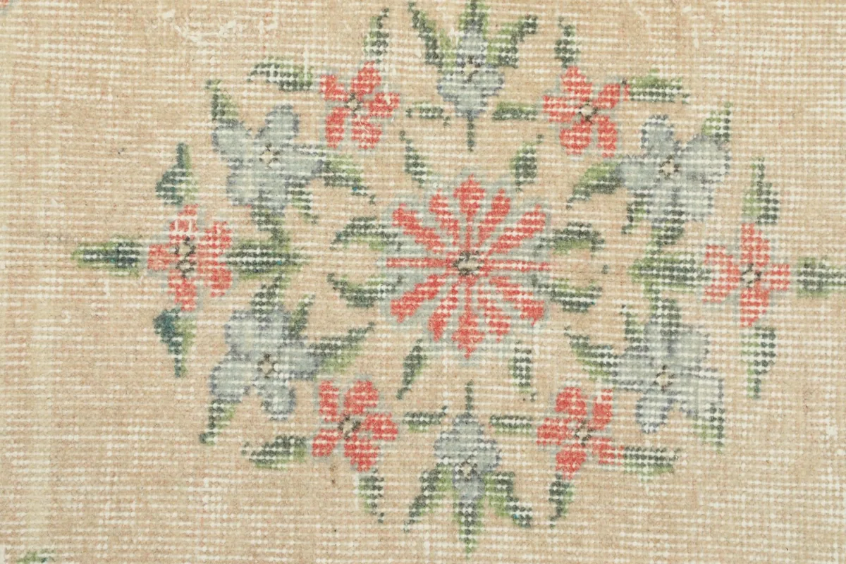 Macro detail of the hand-knotted wool pile and the intricate floral design texture.
