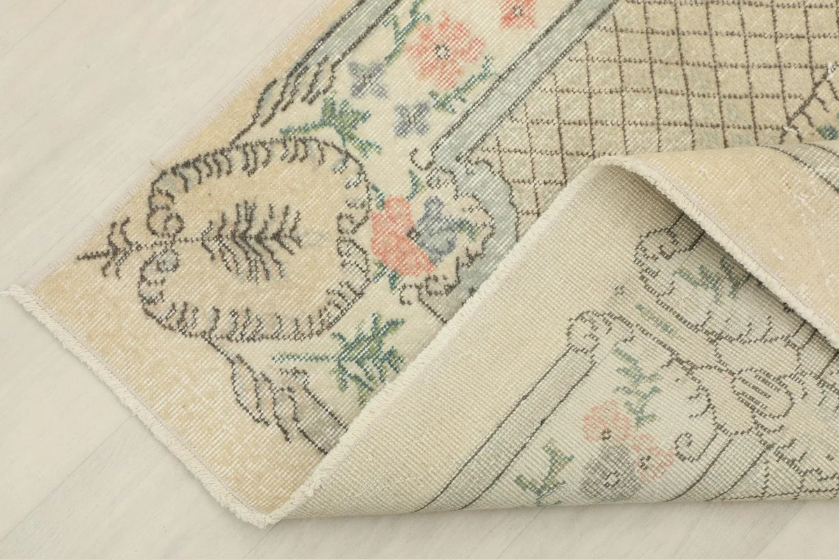 Corner folded to reveal the back of the rug, showing the hand-knotted cotton foundation.