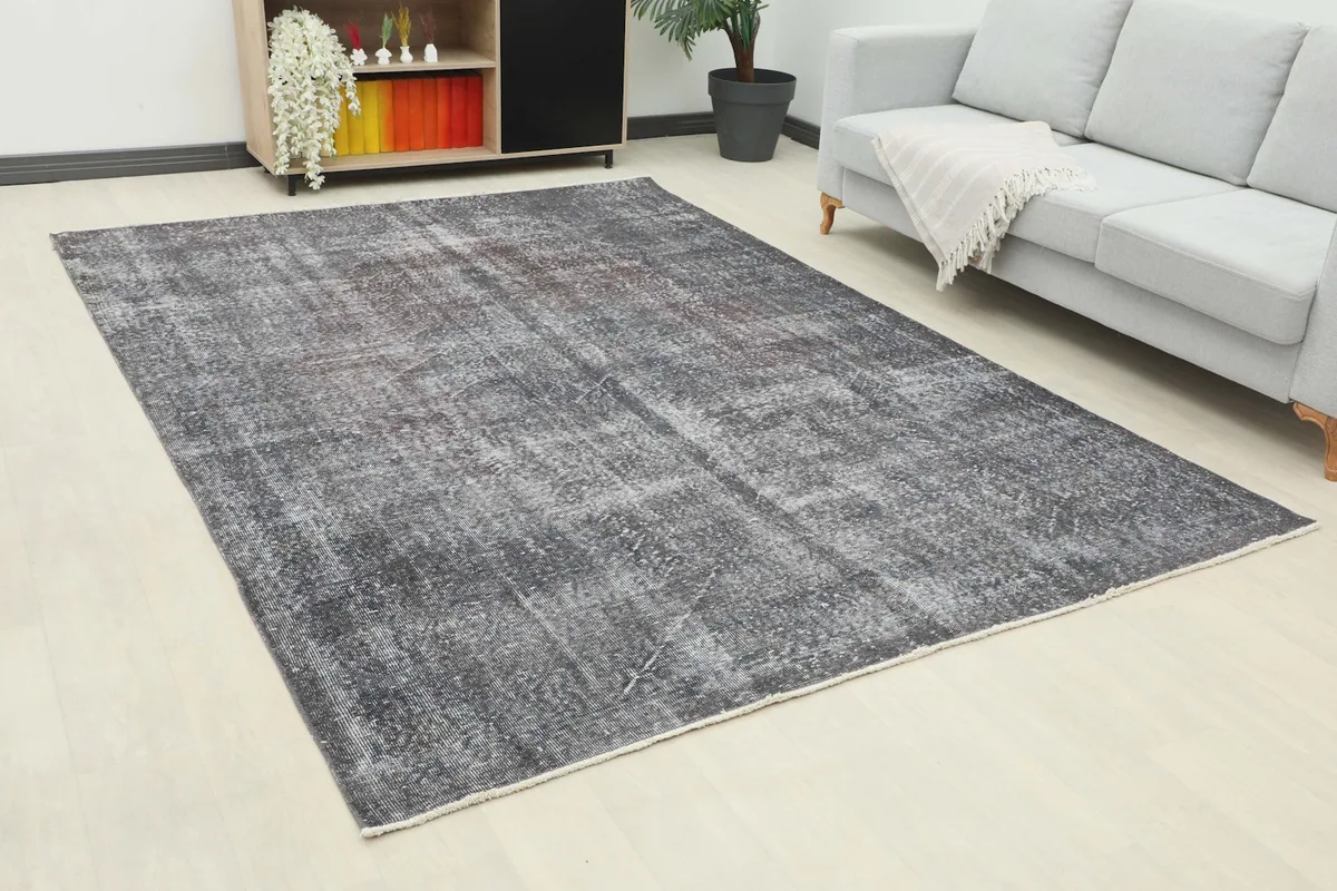 Vintage charcoal area rug in a living room, showing its full size