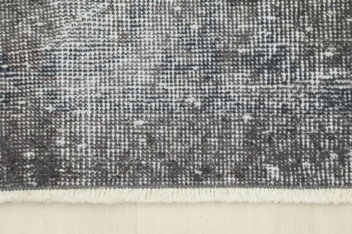 Close-up of the short, subtle fringes on the edge of the vintage rug