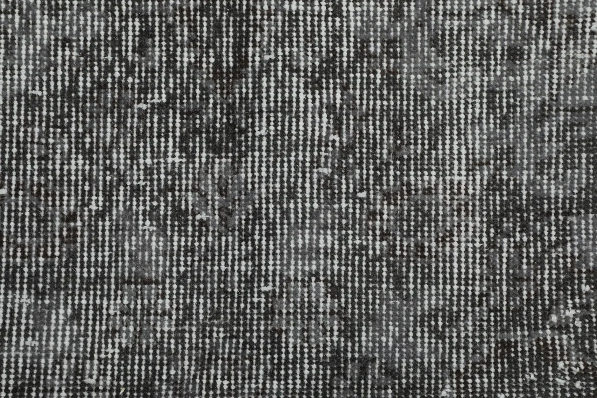 Close-up of the low wool pile, revealing the texture and subtle weave of the vintage rug.