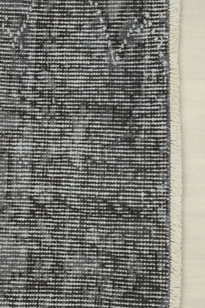 Detail of the rug's edge, showing the short fringe and the tightly woven finish.