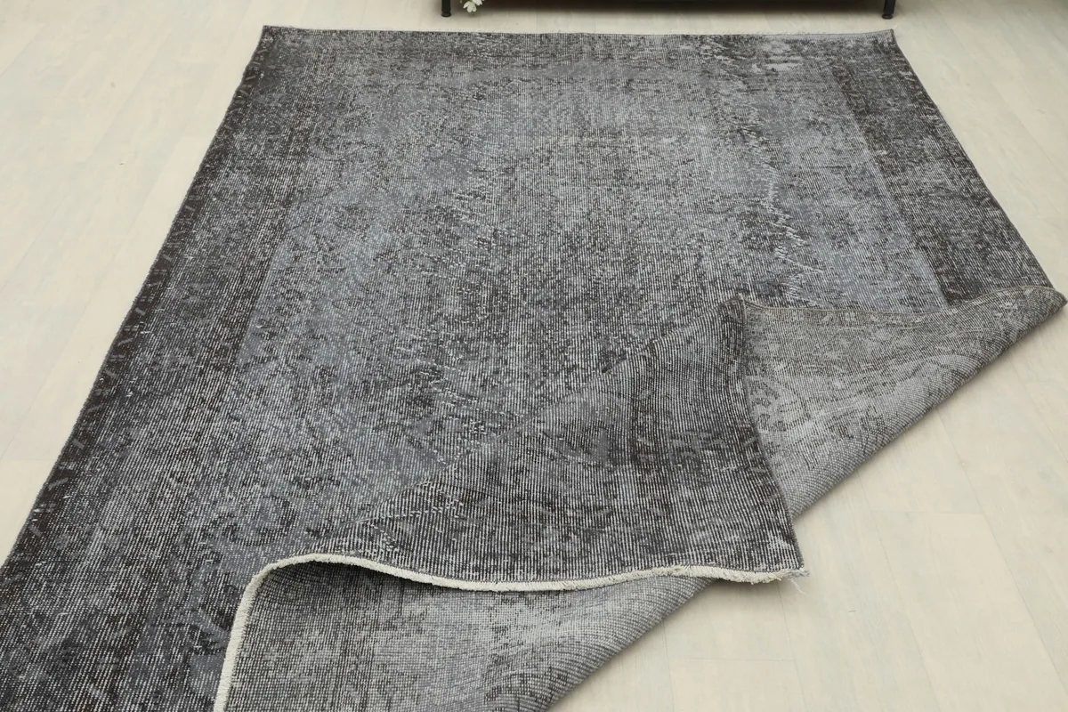 Rug partially folded, displaying both the top surface and the back of the vintage Anatolian piece.