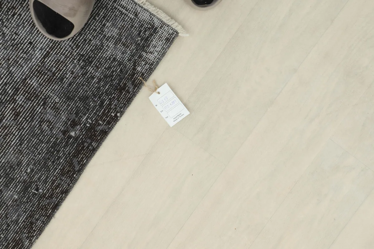 Overhead shot of a corner of the rug with a tag, showing the texture and color variation.