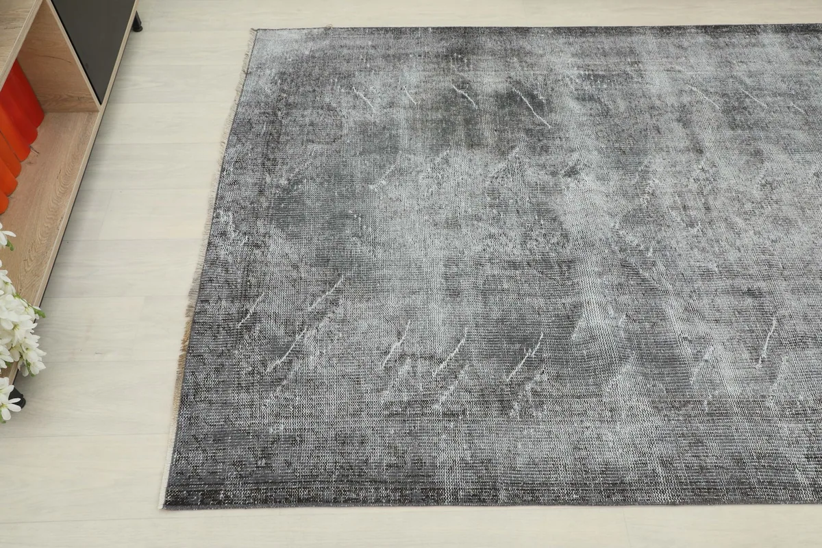 Another angle shot of the vintage rug, showing the blend of charcoal and light gray tones