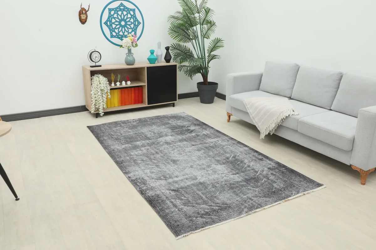 Vintage charcoal rug displayed in a modern living room setting with a light gray sofa