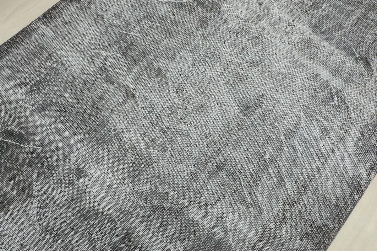Detailed view of the rug's surface, revealing the subtle, worn-down tribal motifs and color variations