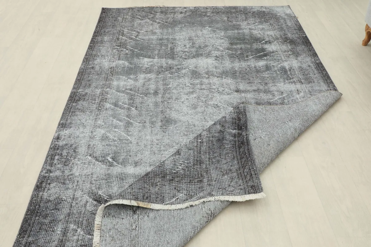 The rug partially folded to display its flexibility and the construction of the back