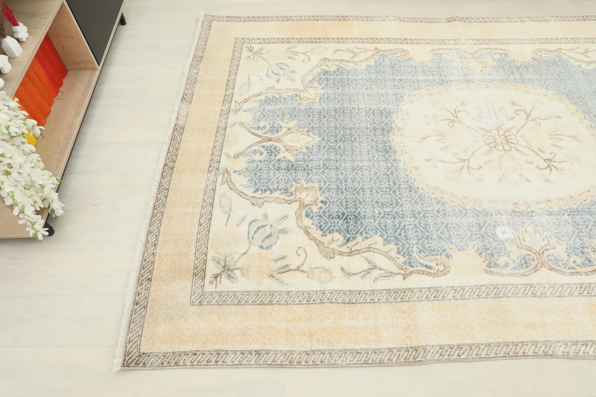 Overhead angle showing the blue field and cream border of the vintage Anatolian rug