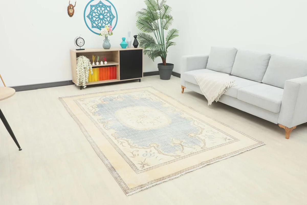 Vintage blue and cream rug placed in a modern living room setting with a light gray sofa