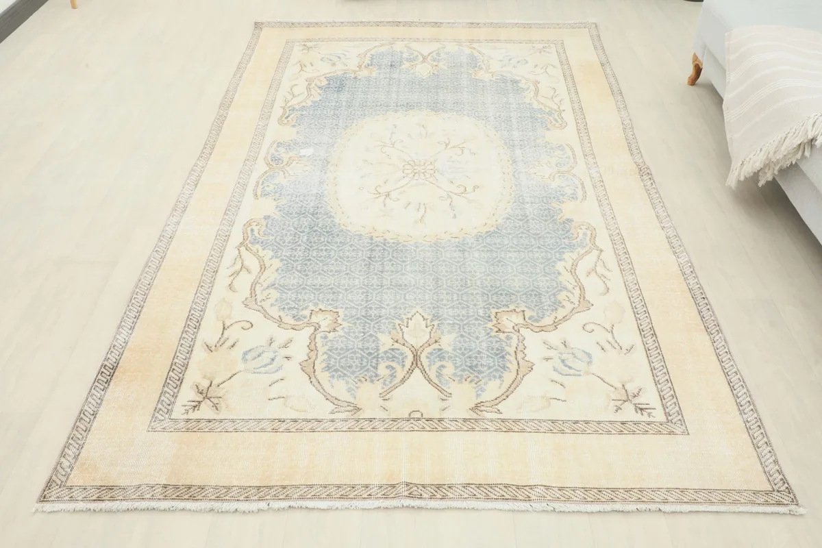 Full overhead view of the vintage blue and cream rug, demonstrating its complete design and colors
