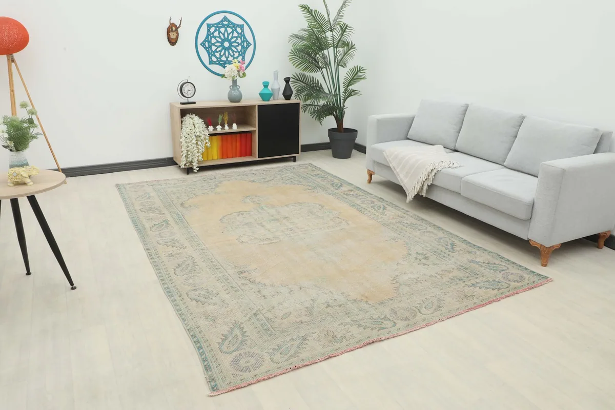 Vintage beige and green area rug displayed in a modern living room setting