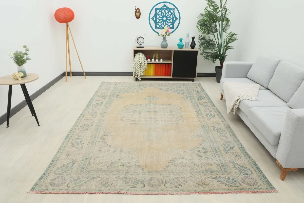 Full room view of the beige and green vintage Anatolian rug providing warmth to the space