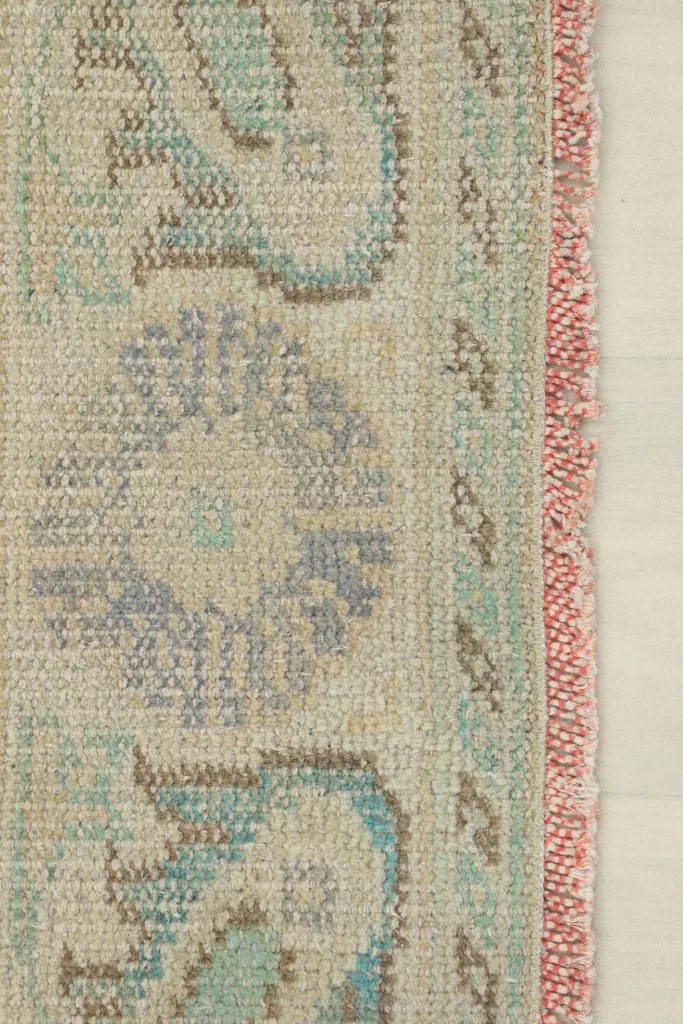 Close-up of the rug's edge, highlighting the hand-knotted detail and subtle red selvedge