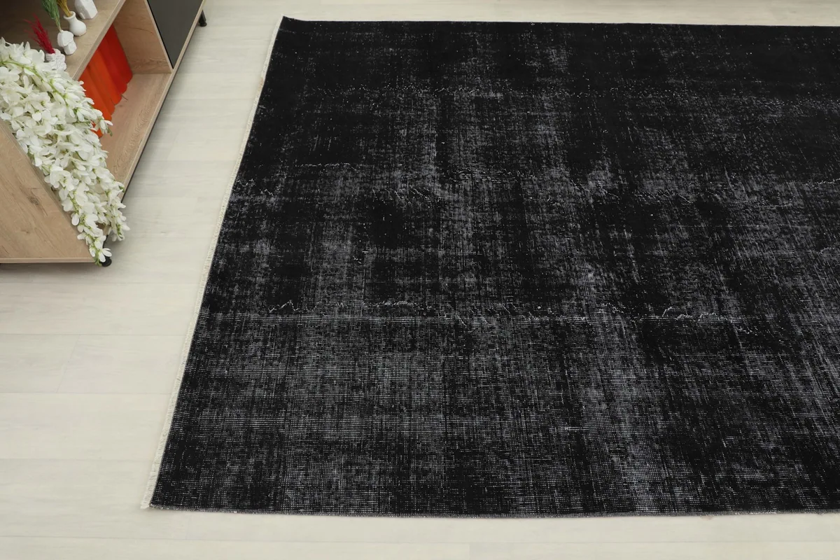 Another angle highlighting the faded black and gray tones and vintage character of the rug