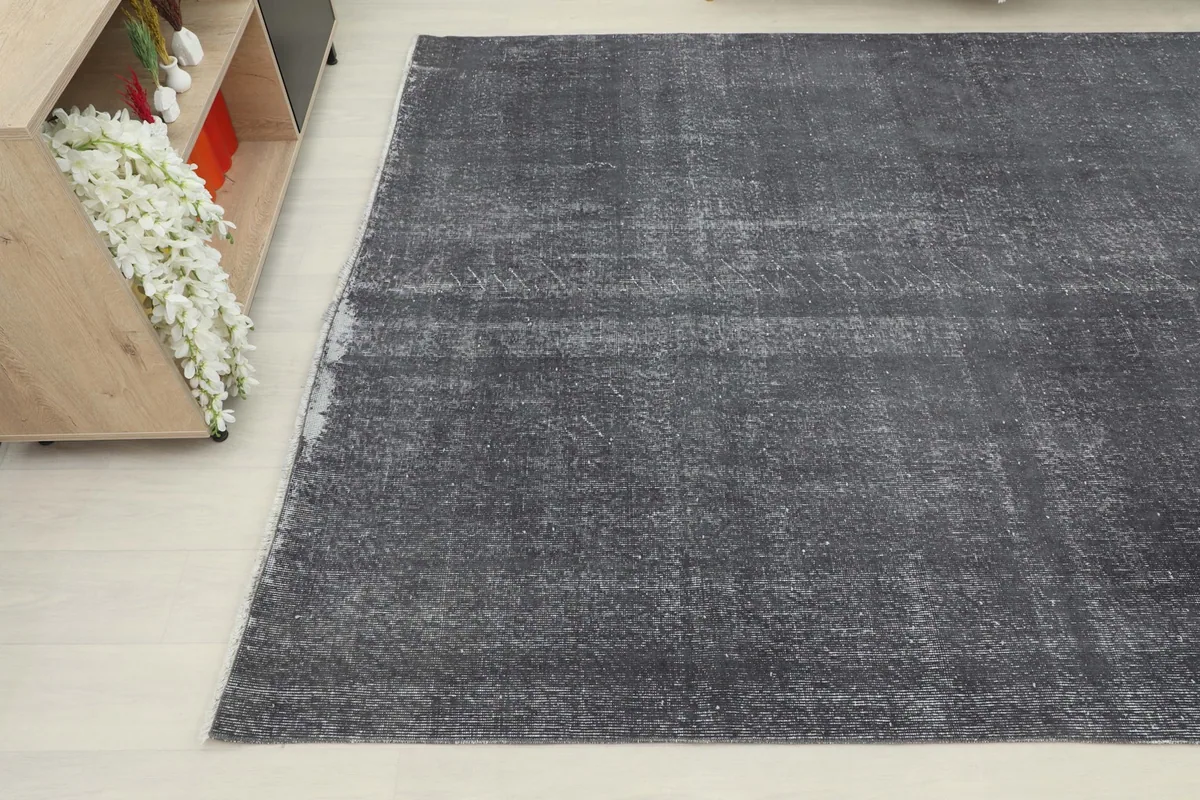 Angled view of the rug's corner, highlighting its distressed appearance