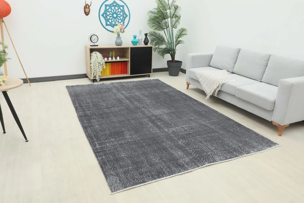 Charcoal gray rug placed in a living room setting with a light sofa