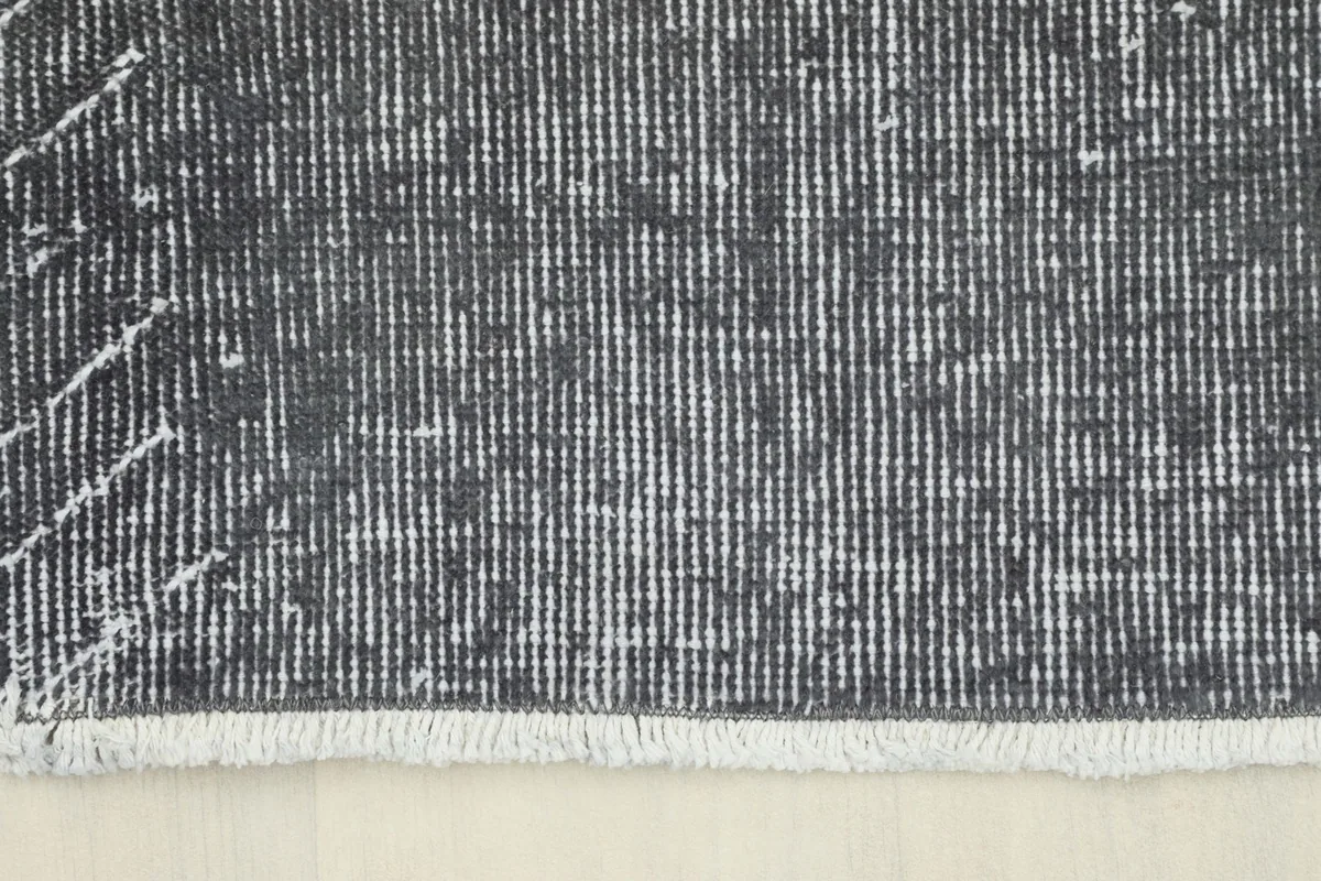 View of the rug's short, light-colored fringe at one end