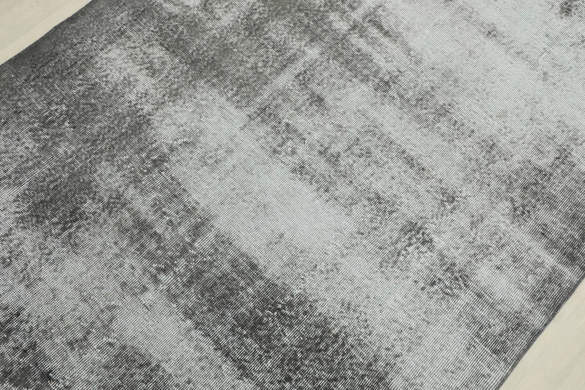 Detailed view of the rug's abstract pattern and distressed finish, focusing on the interwoven colors.