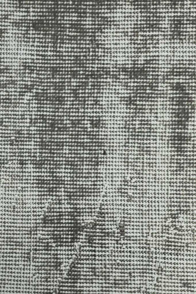 Macro view of the low wool pile, showing the hand-knotted construction and texture of the fibers.