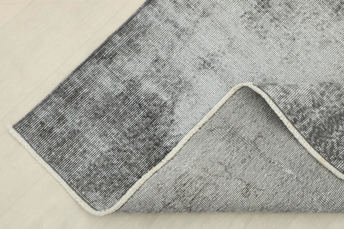 View of the rug's underside, revealing the cotton foundation and hand-knotted structure.