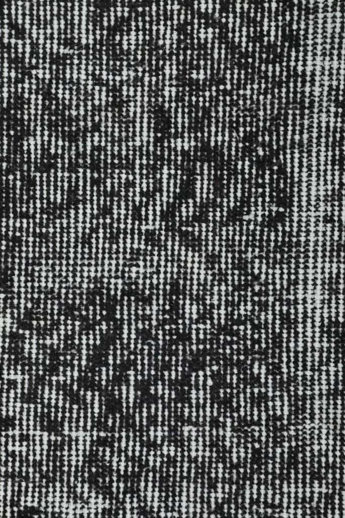 Close-up showing the low pile and texture of the hand-knotted charcoal and gray rug.