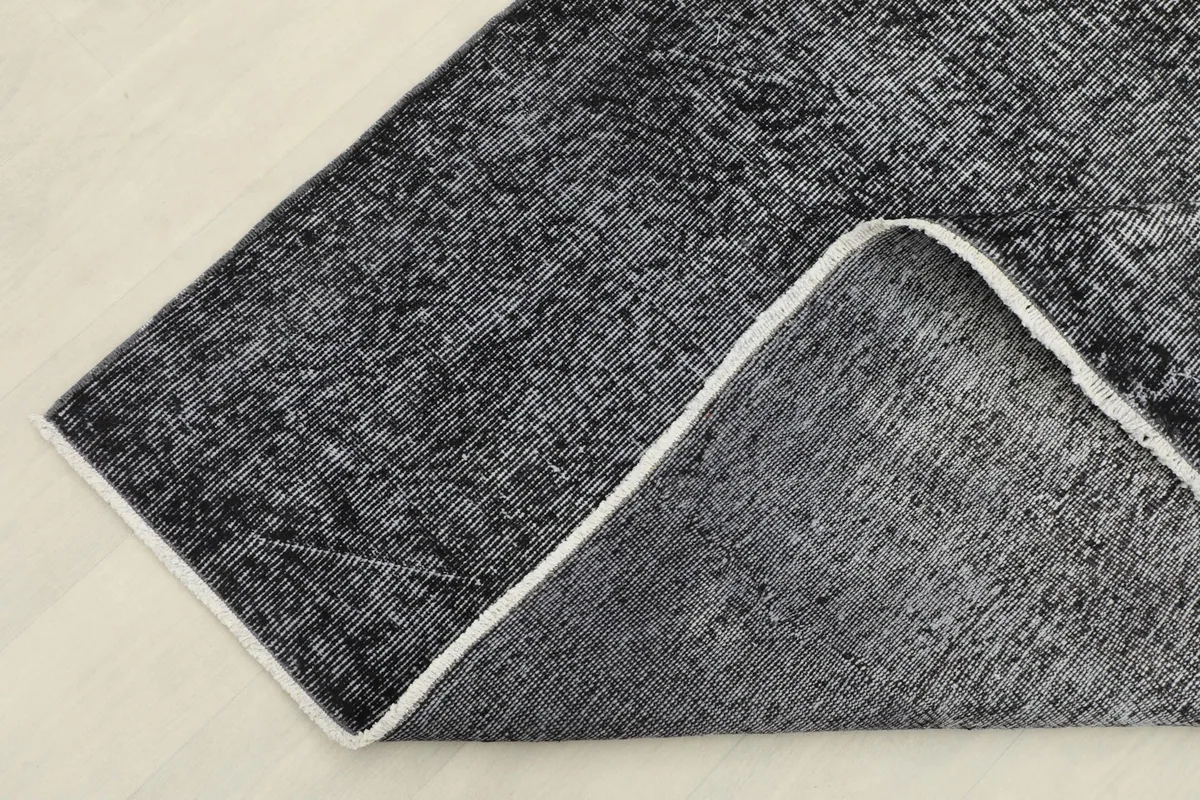 View of the back of the rug, showing the cotton foundation and hand-knotted construction.