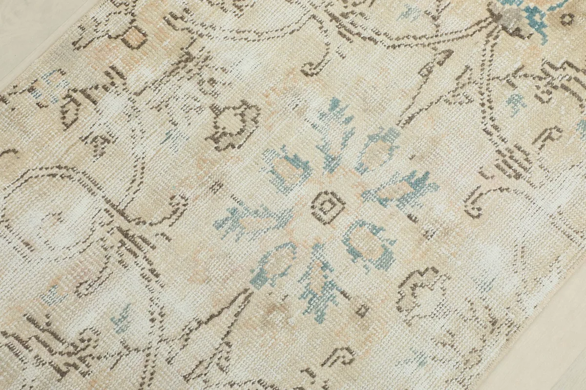 Detailed view of the central floral motif in blue and brown, showing the rug's texture and patina.