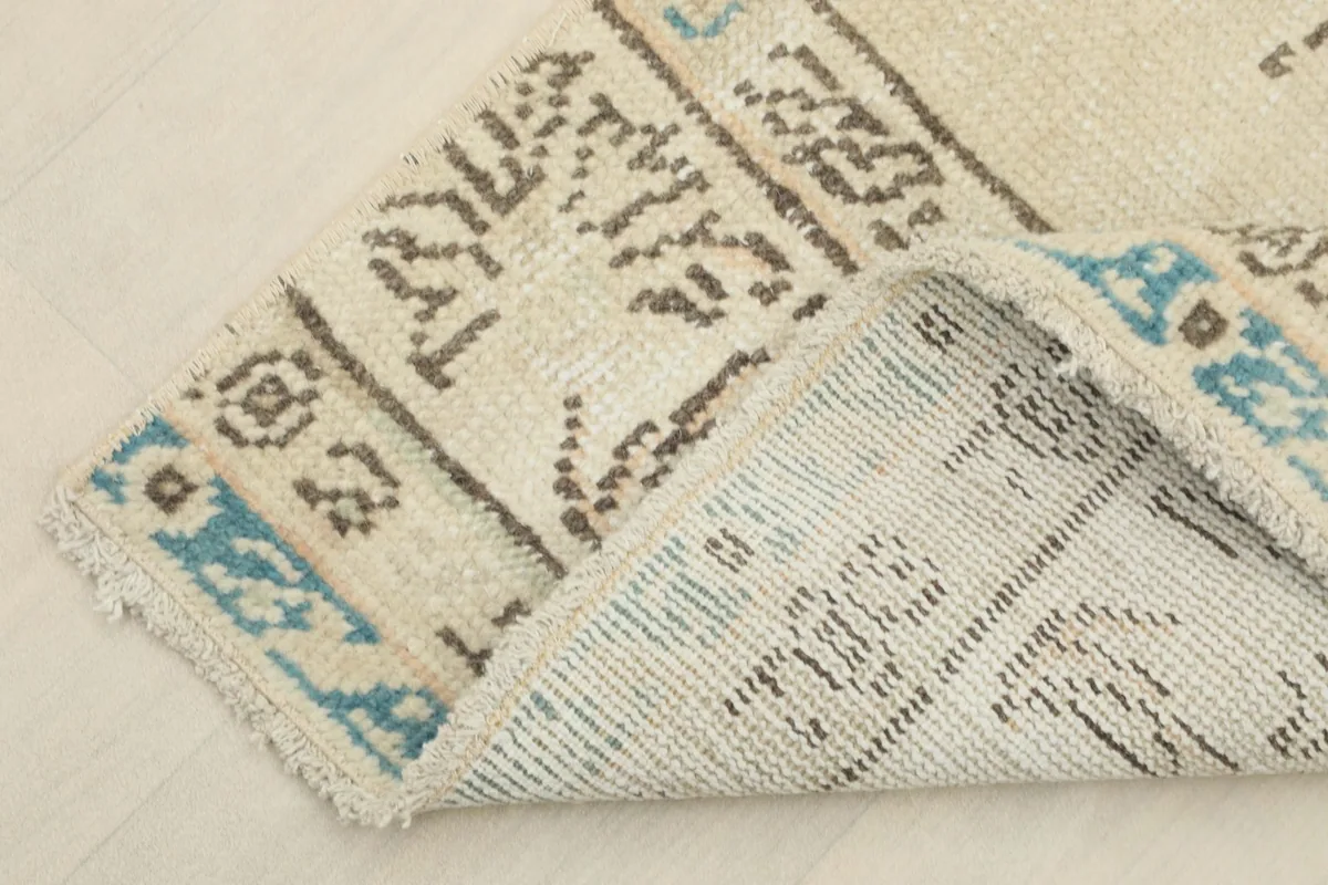 View of the back of the rug, showing the cotton foundation and hand-knotted construction.