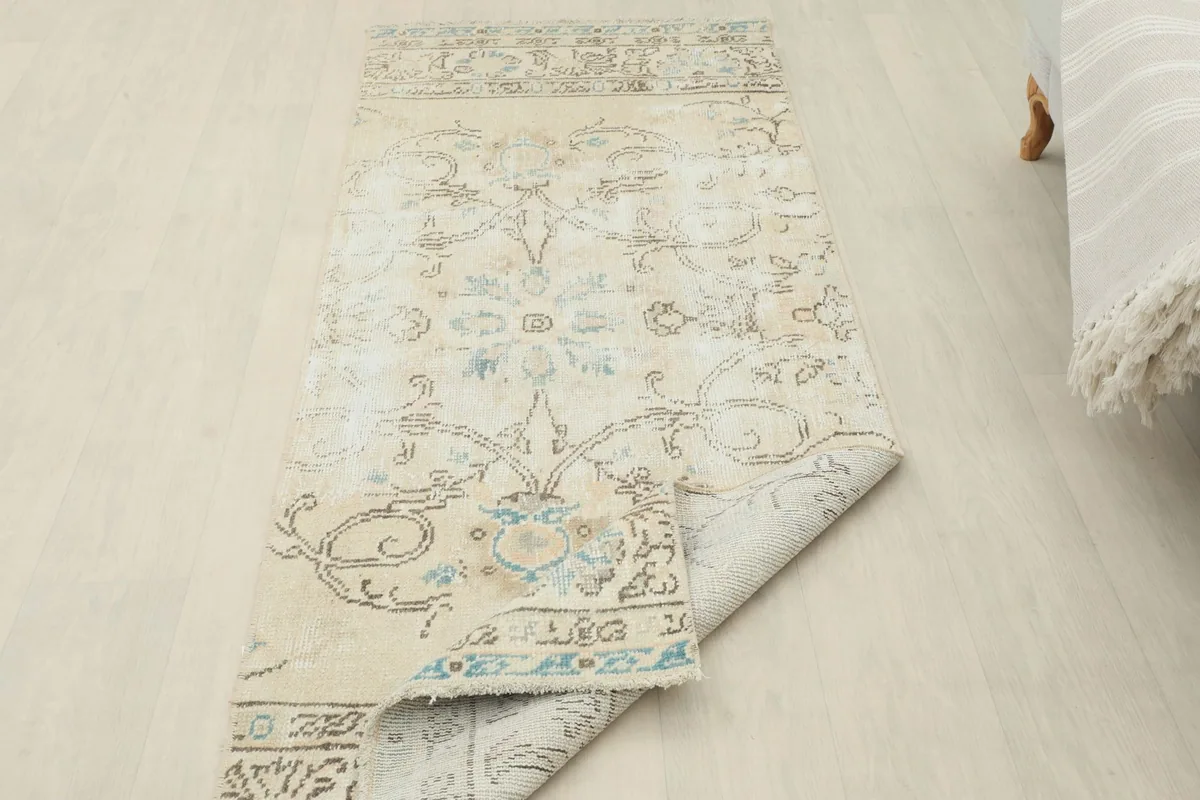 Runner rug partially folded, showing the thickness of the wool pile and the foundation.