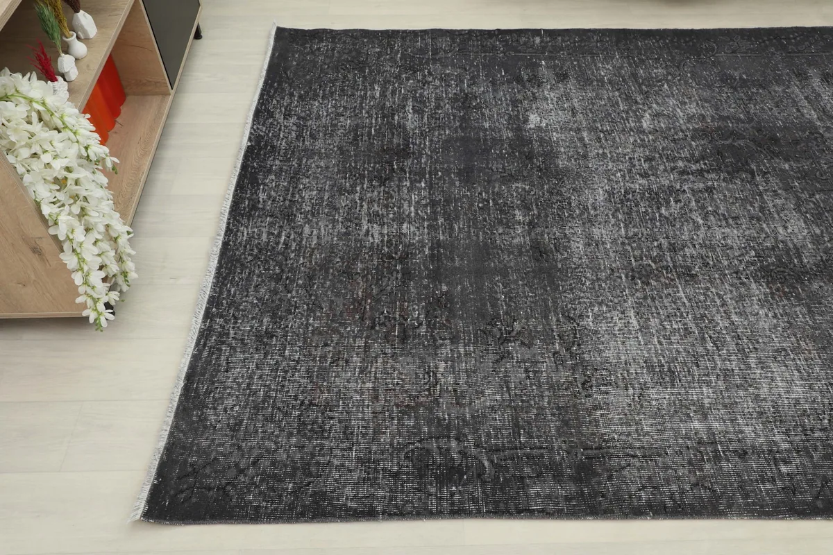 Another corner view of the distressed charcoal rug, showing its texture and color variation