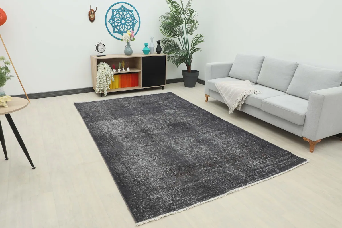 Charcoal gray rug placed in a modern living room setting with a light gray sofa