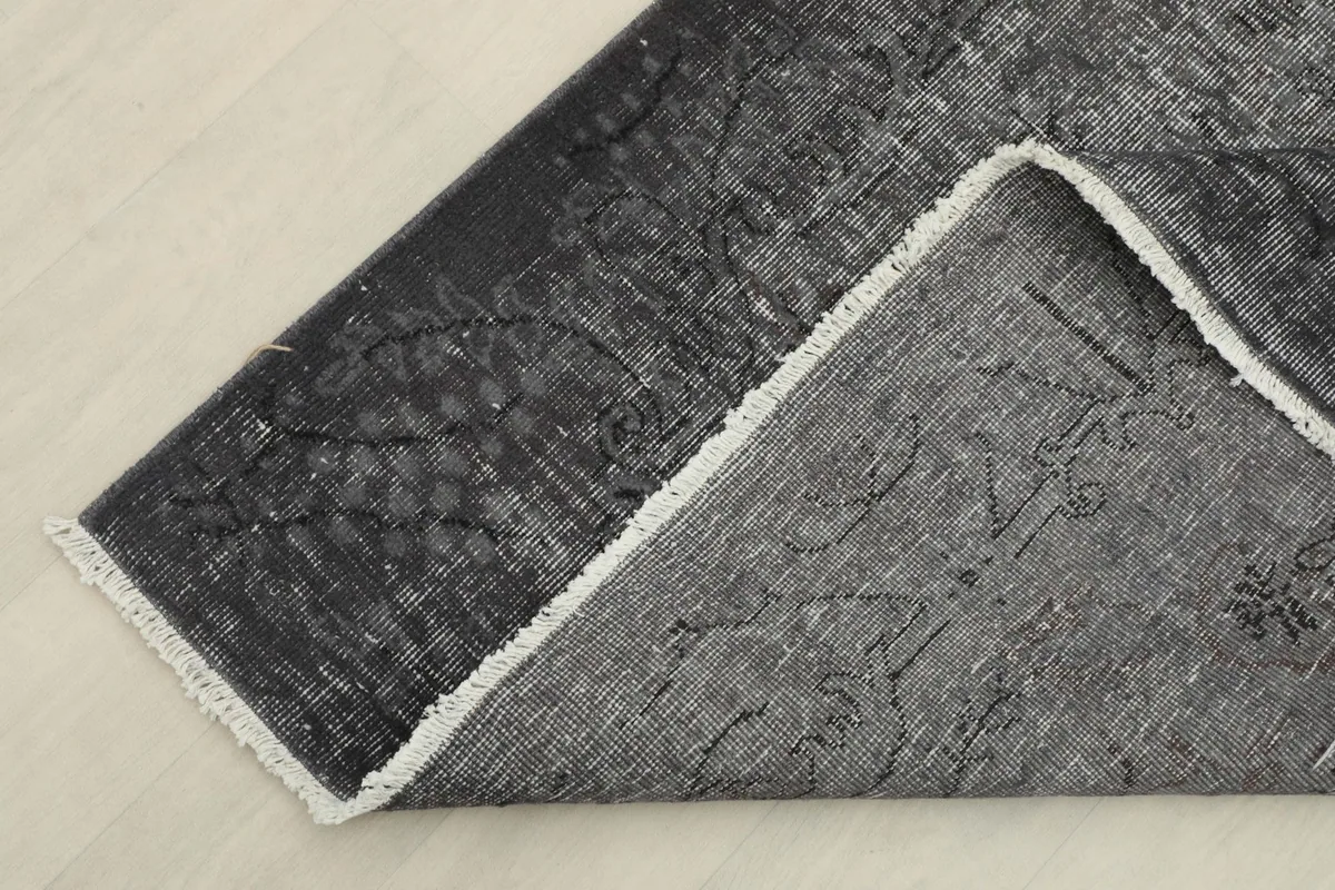 Close-up of the rug's back, showing the cotton foundation and hand-knotted structure