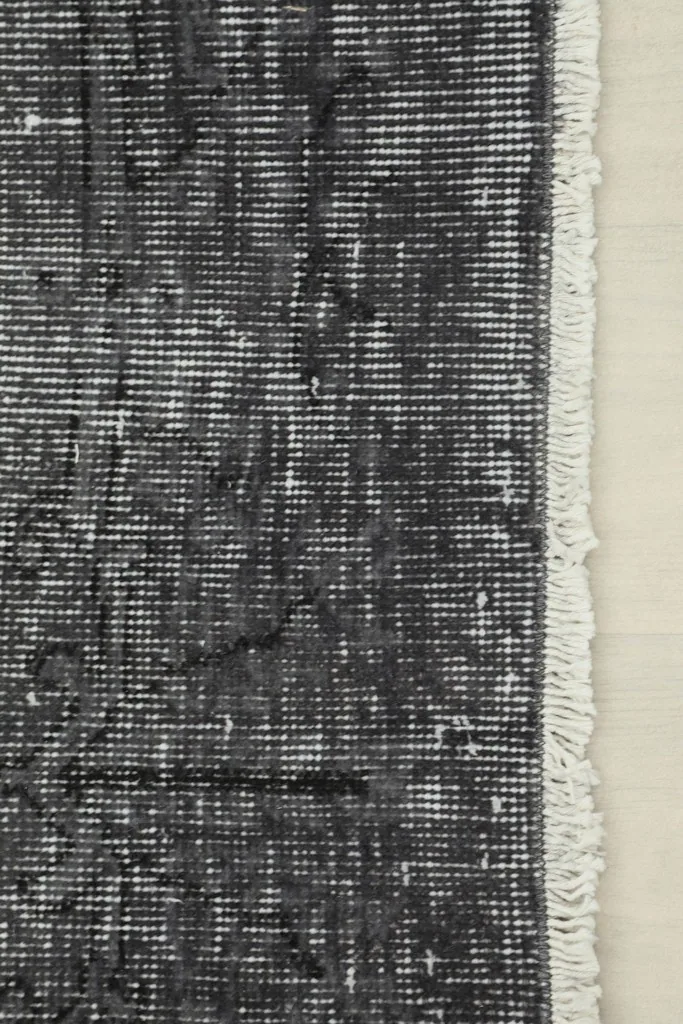 View of the rug's edge, showing the short, natural cotton fringe and foundation