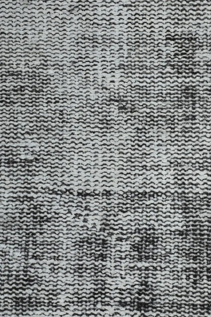 Close-up of the low wool pile, showing the hand-knotted texture and distressed areas