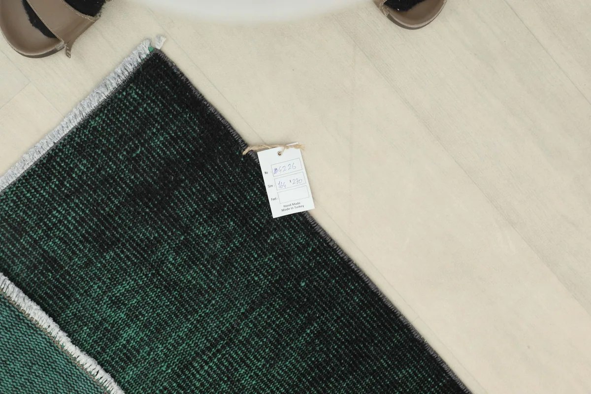 View of the rug's corner with a product tag, indicating its origin and materials.