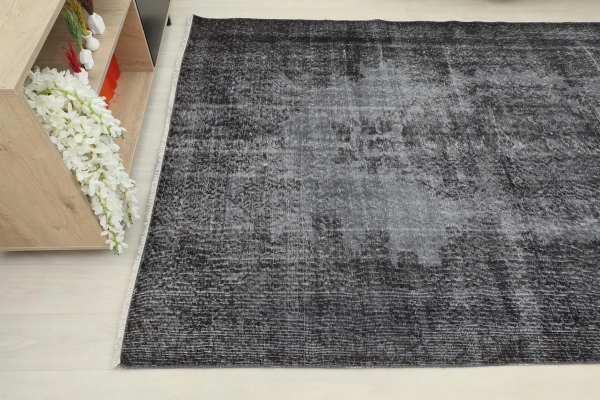Angled view of the charcoal area rug, showing its texture and color variations