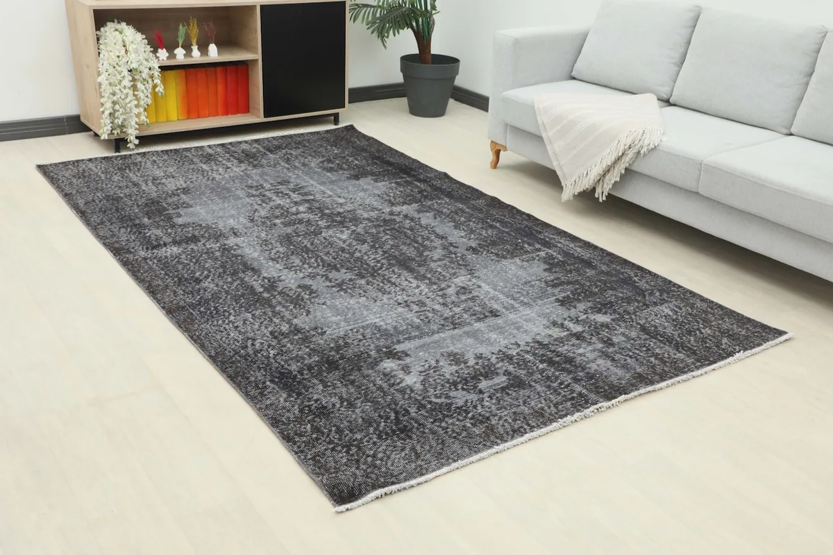 Angled view of the charcoal gray rug in a living room, showing its placement relative to furniture