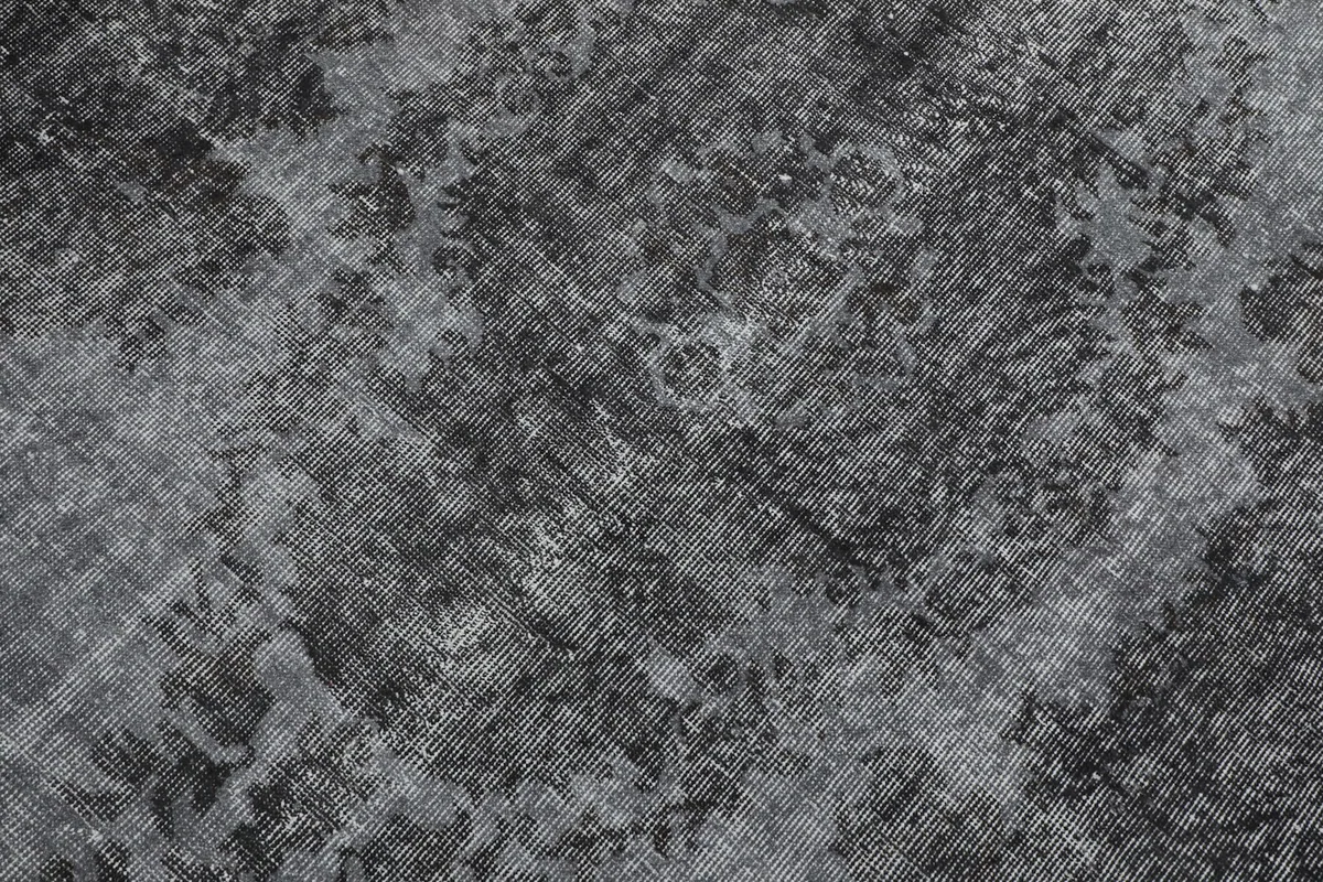 Detailed close-up of the rug's distressed wool pile and abstract pattern