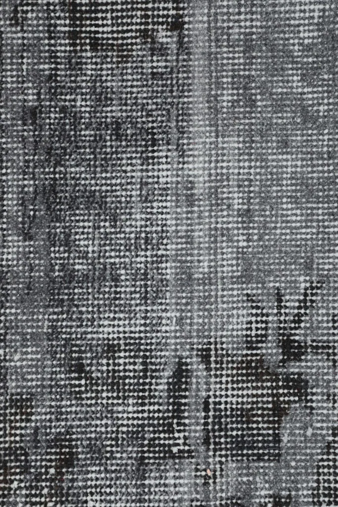 Close-up of the hand-knotted wool pile, showing the intricate distressed weave