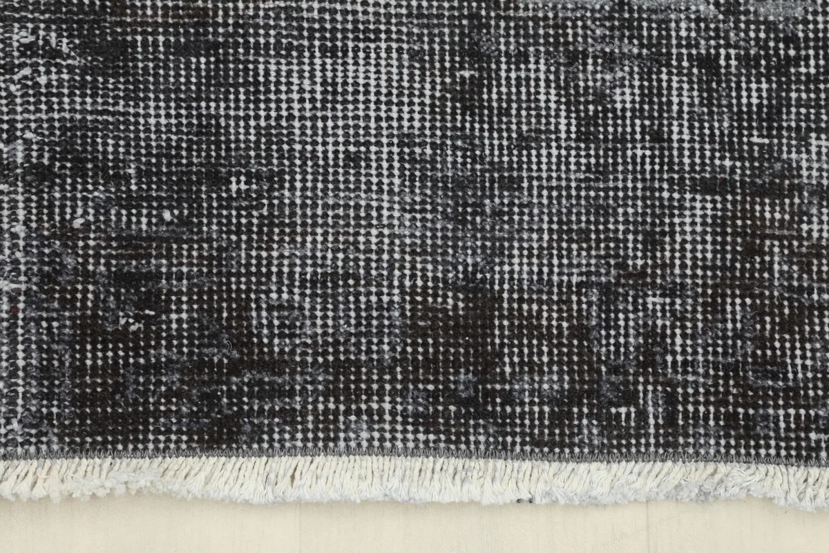 Detail of the rug's short, natural colored fringe and the edge of the pile