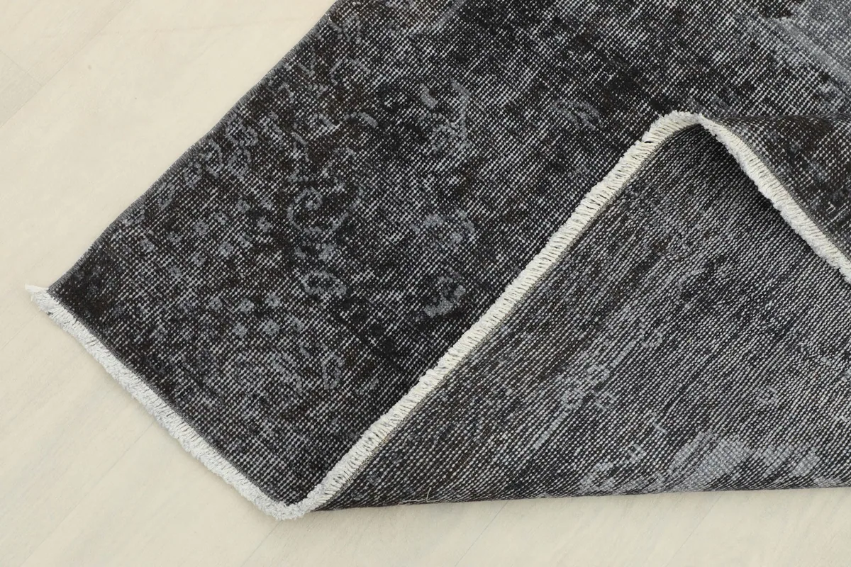 Close-up of a folded corner, showing the quality of the hand-knotted construction and foundation